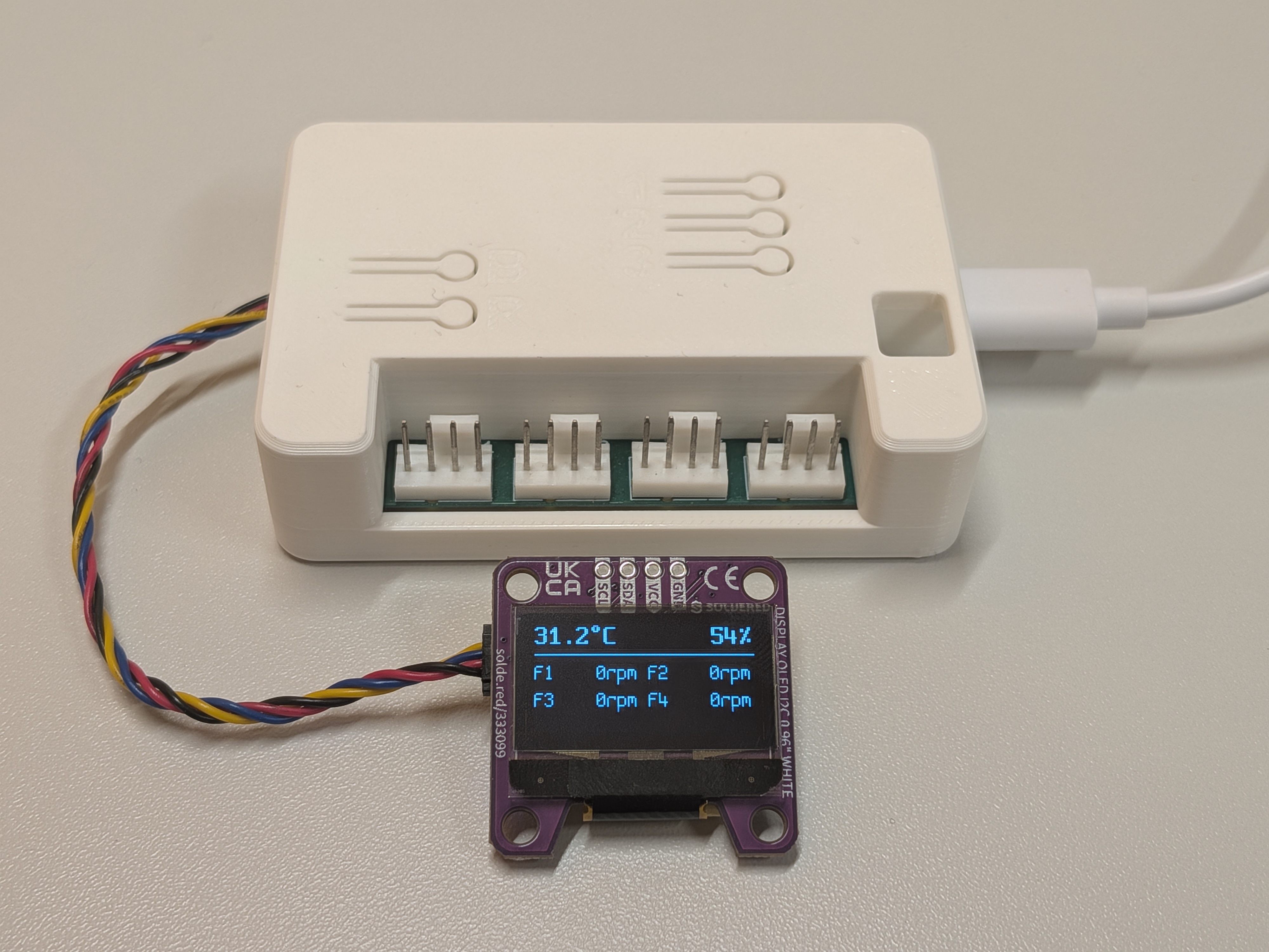 WiFi Fan Controller with a Soldered SSD1306 OLED connected over Qwiic, showing 31.2 degrees Celsius, 54 percent humidity, and the RPM of all four fans